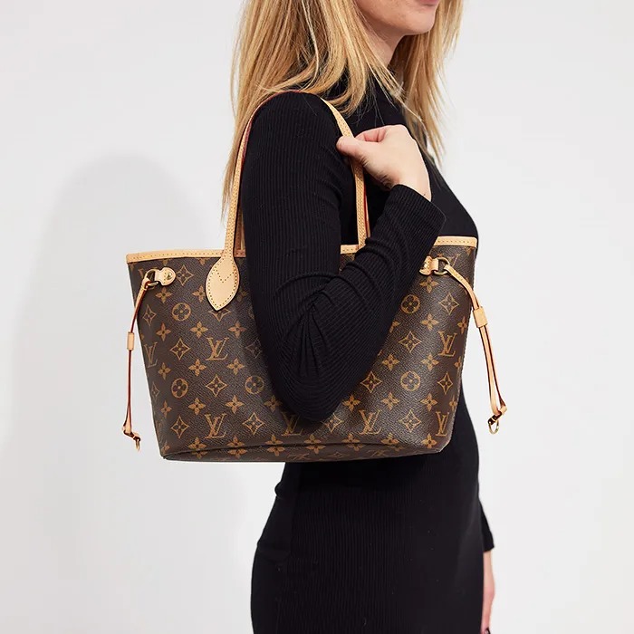 Mujer con bolso Louis Vuitton Neverfull PM monograma en el hombro